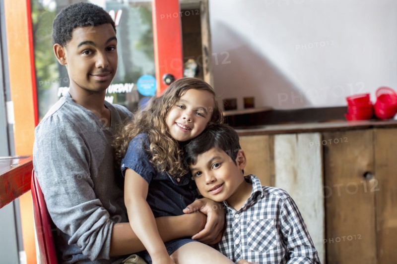 Mixed race brothers and sister smiling together