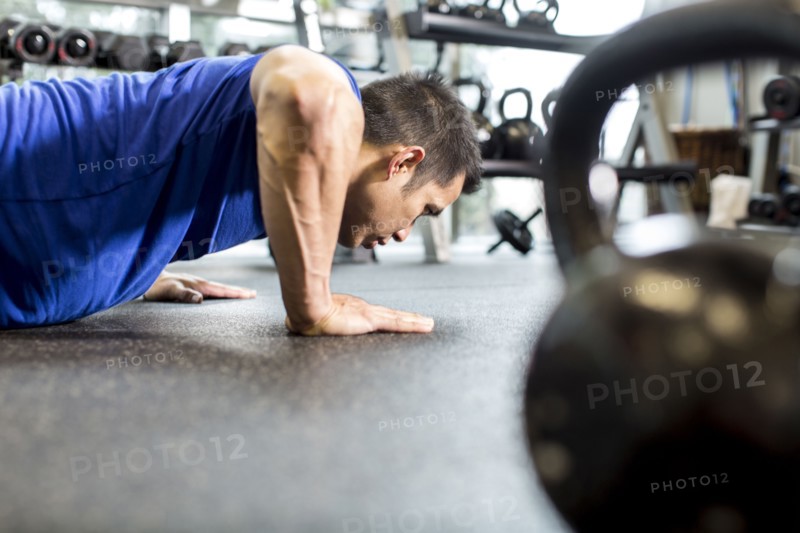 Pacific Islander man working out in gym