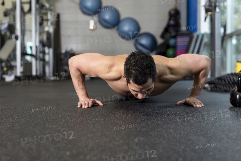 Pacific Islander man working out in gym