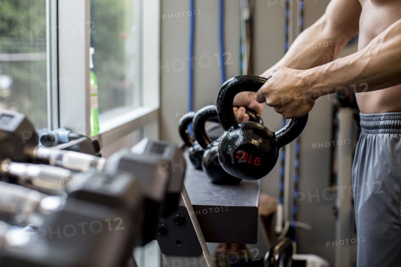 Pacific Islander man lifting weights in gym