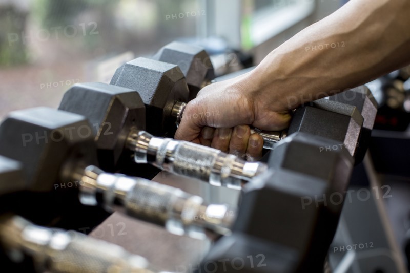 Pacific Islander man lifting weights in gym