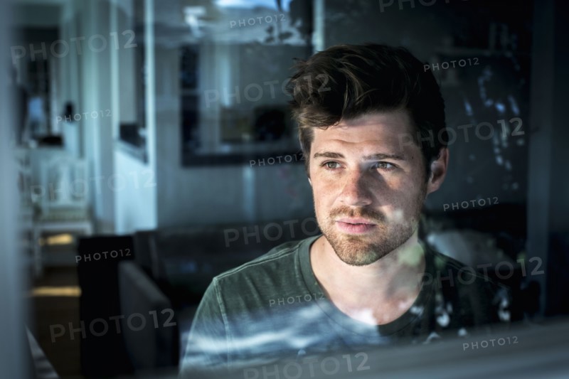 Man looking out window