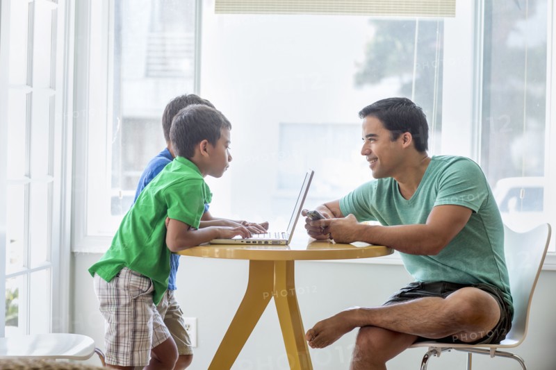 Father and sons talking at table