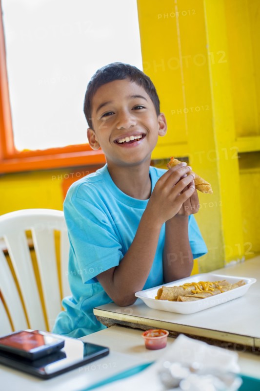 Hispanic boy eating in restaurant