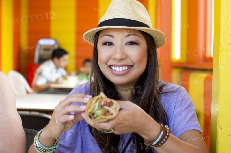 Asian woman eating in restaurant