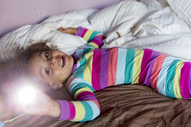 Mixed race girl smiling on bed