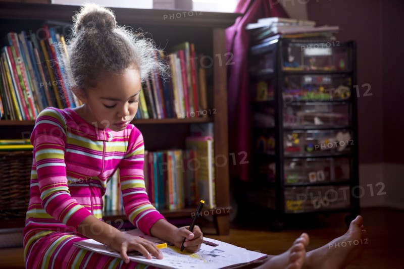 Mixed race girl drawing in living room