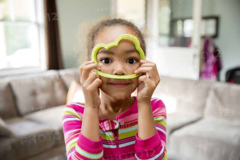 Mixed race girl playing with cookie cutter