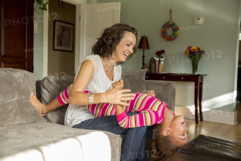 Mother and daughter playing in living room