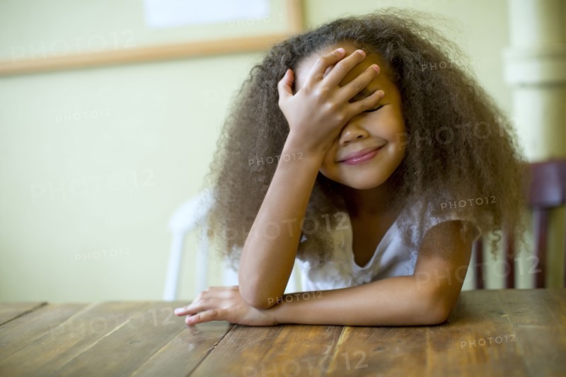 Mixed race girl laughing at table