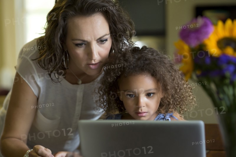 Mother and daughter using laptop