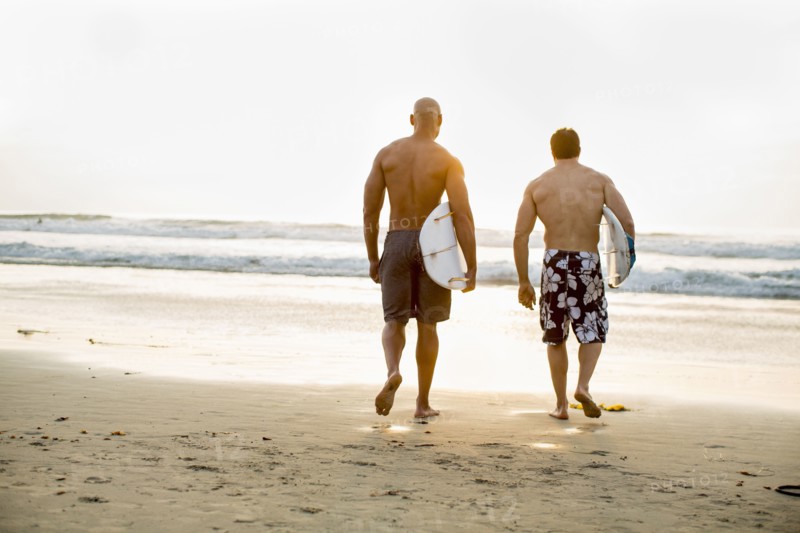 Men carrying surfboards on beach