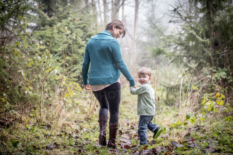 Caucasian mother and son walking in forest