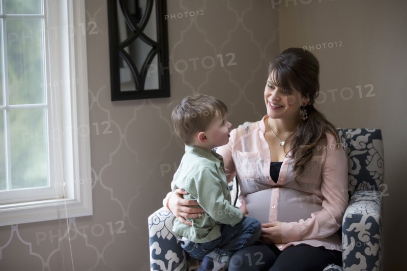 Pregnant Caucasian mother sitting with son