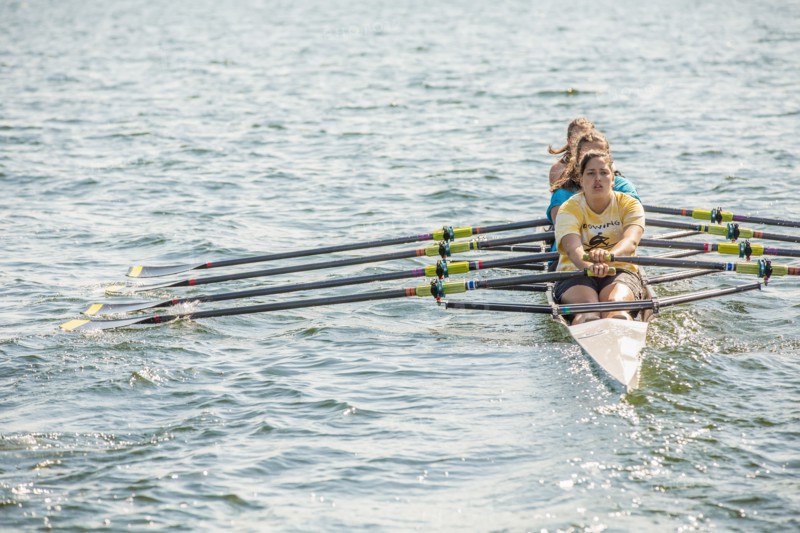 Teenagers rowing together on lake