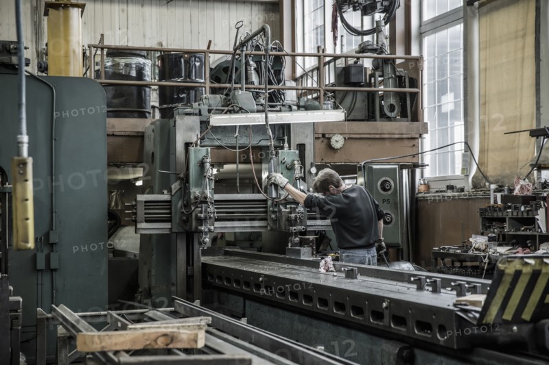 Caucasian man using machinery in metal shop