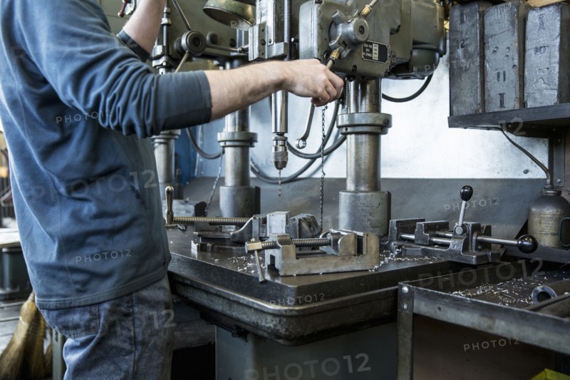 Caucasian man using drilling machine in workshop