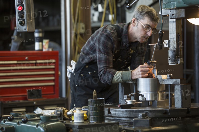 Caucasian man using machinery in workshop