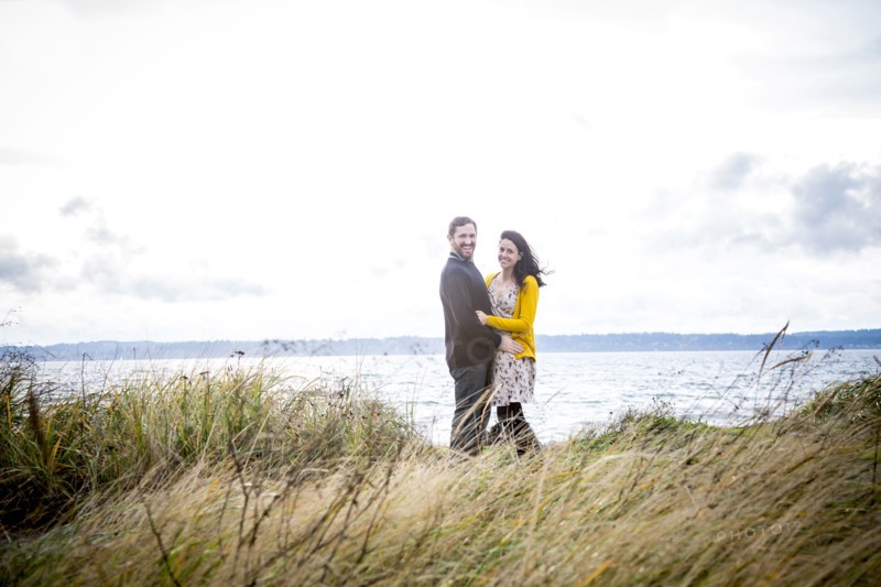 Caucasian couple hugging on grassy beach