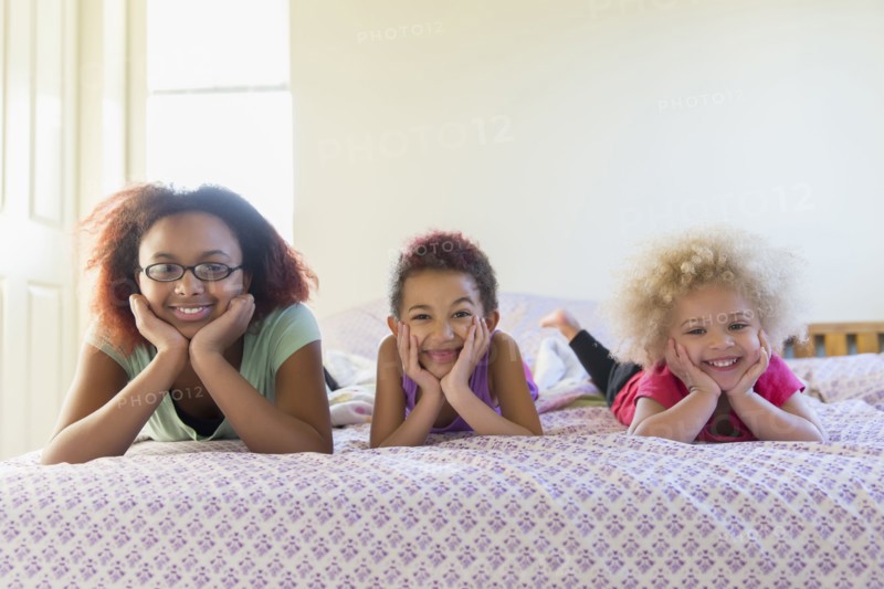 Mixed race sisters laying in bed