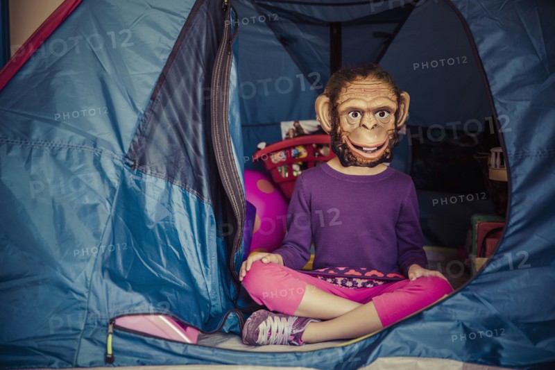 Mixed race girl wearing mask in tent