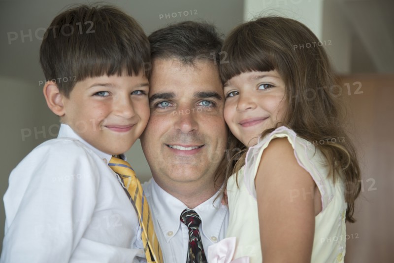 Caucasian father and children smiling in formal wear