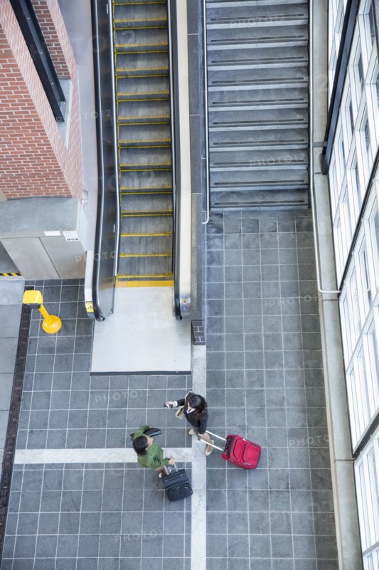 Businesswomen talking near stairs and escalator