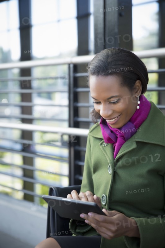 Black businesswoman using digital tablet on train platform