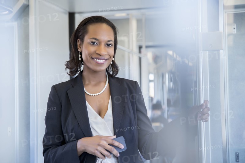 Black businesswoman smiling on train