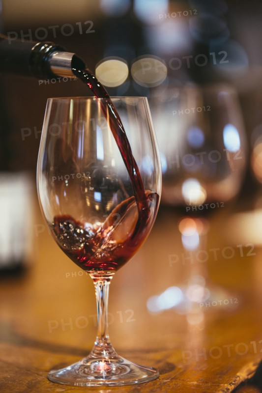Close up of wine pouring into glass on table