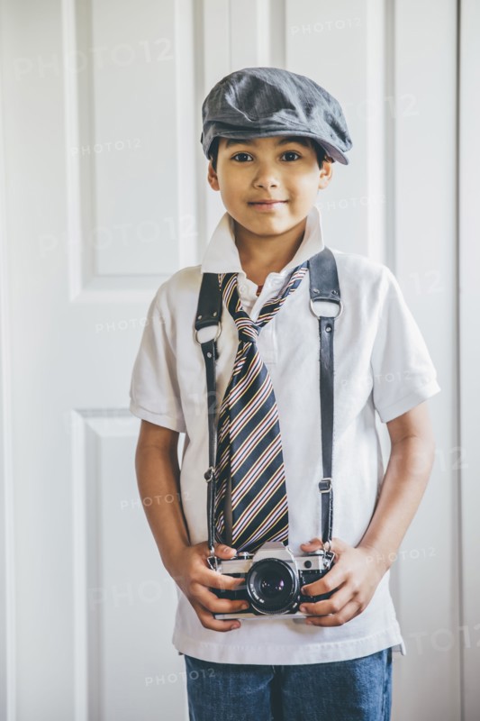 Mixed race boy wearing camera on strap
