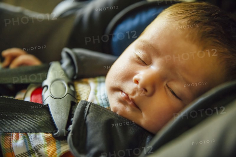 Caucasian baby boy sleeping in car seat