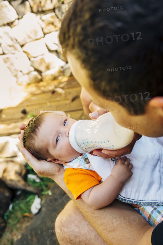 Caucasian father feeding baby boy outdoors