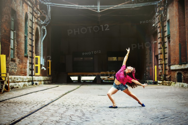 Caucasian woman dancing on cobblestone street