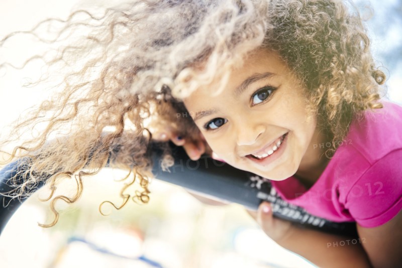 Mixed race girl playing on bicycle rack
