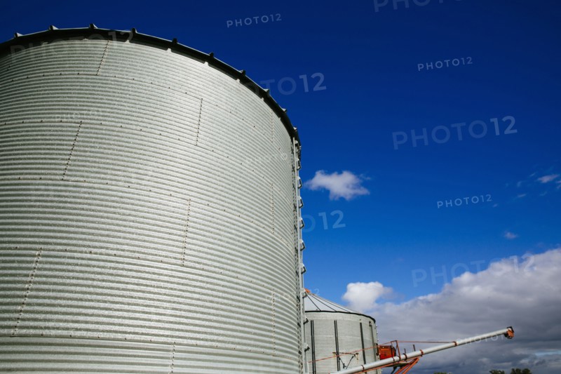 Low angle view of silos under blue sky
