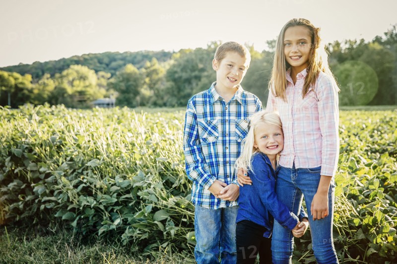 Caucasian children standing in crop field on farm
