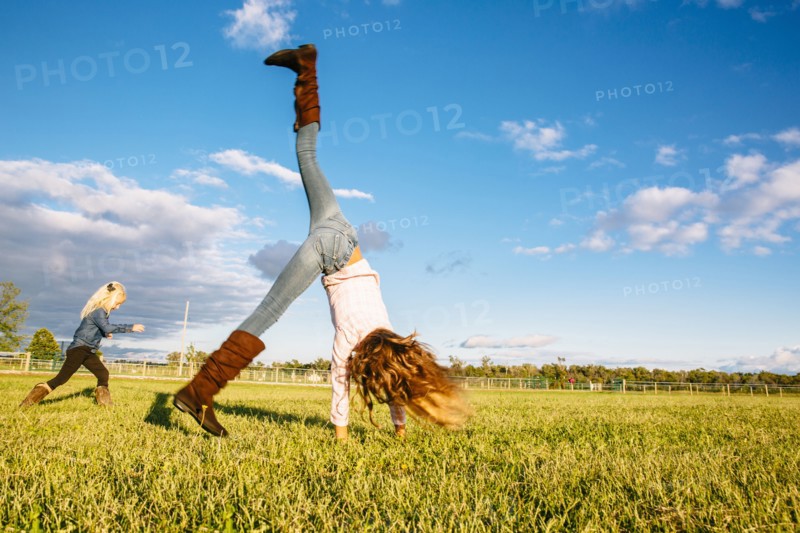 Caucasian girls playing in rural field