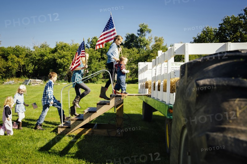 Caucasian children climbing stairs to hay ride on farm