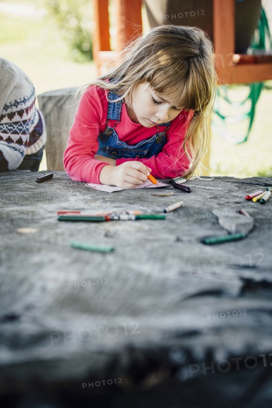 Caucasian girl coloring outdoors