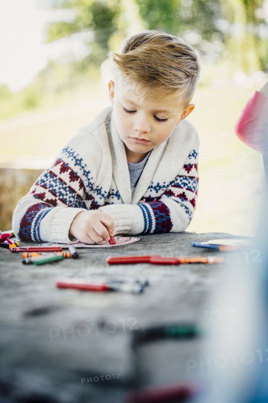 Caucasian boy coloring outdoors