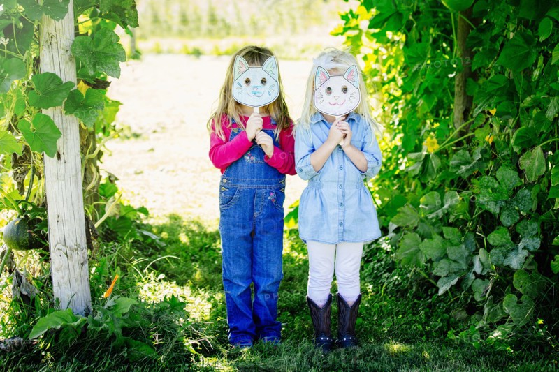 Caucasian girls holding cat mask