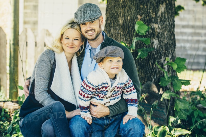 Caucasian family smiling under tree