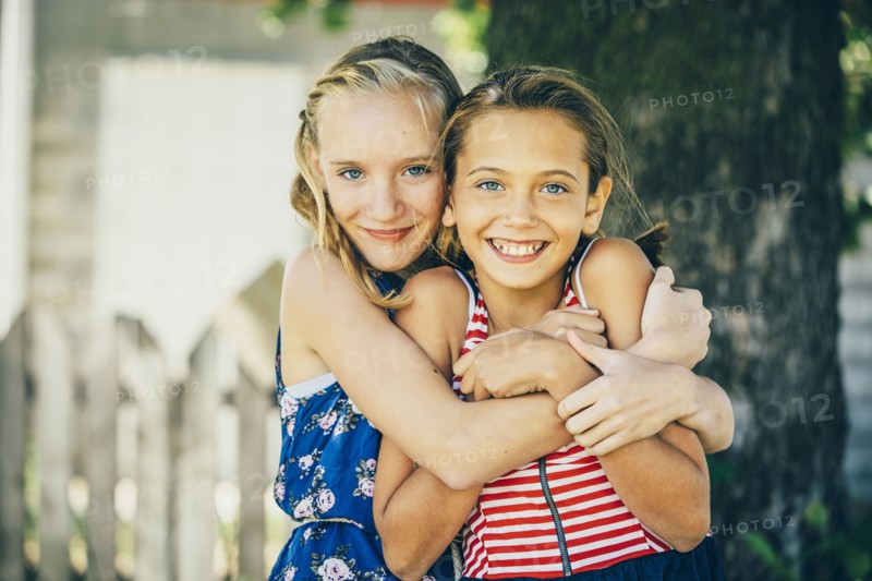 Caucasian girls hugging outdoors