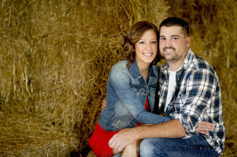 Caucasian couple hugging in haystacks