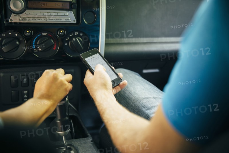 Caucasian man using cell phone in car