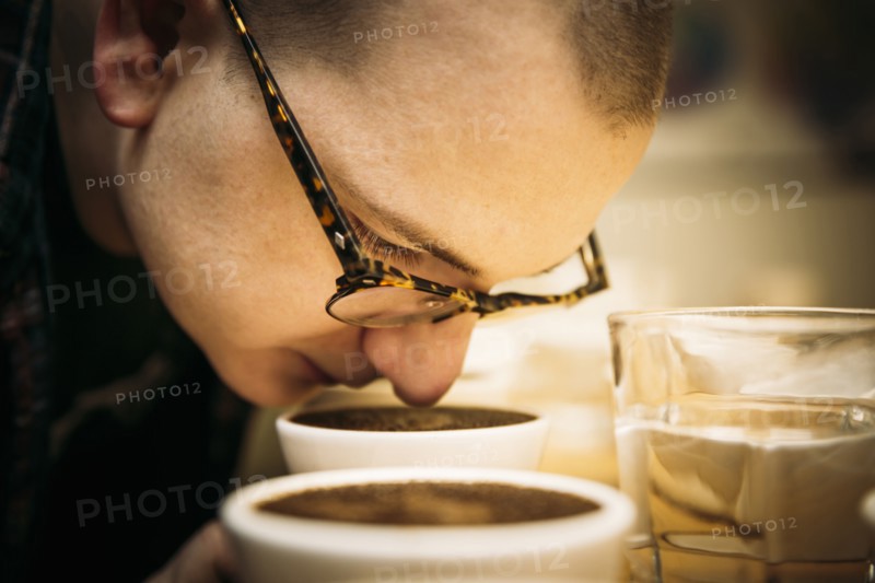 Caucasian barista smelling coffee in cup