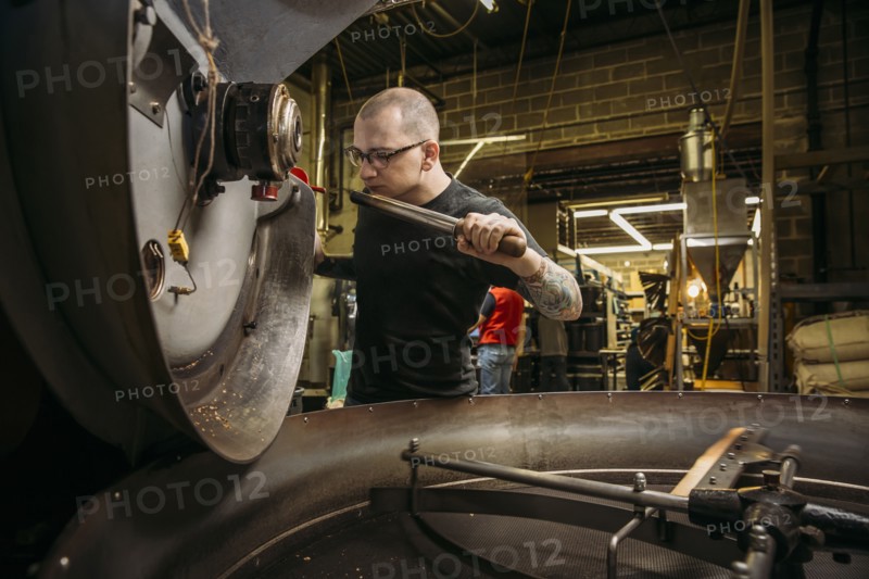 Caucasian roaster working on coffee in warehouse