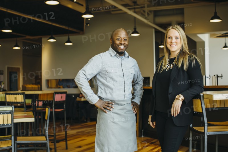 Waiter and businesswoman smiling in cafe