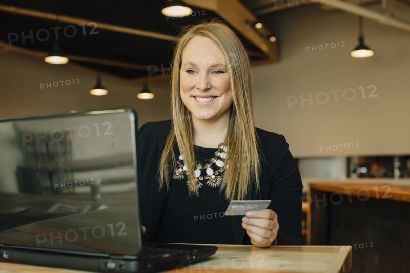 Caucasian businesswoman shopping online in cafe
